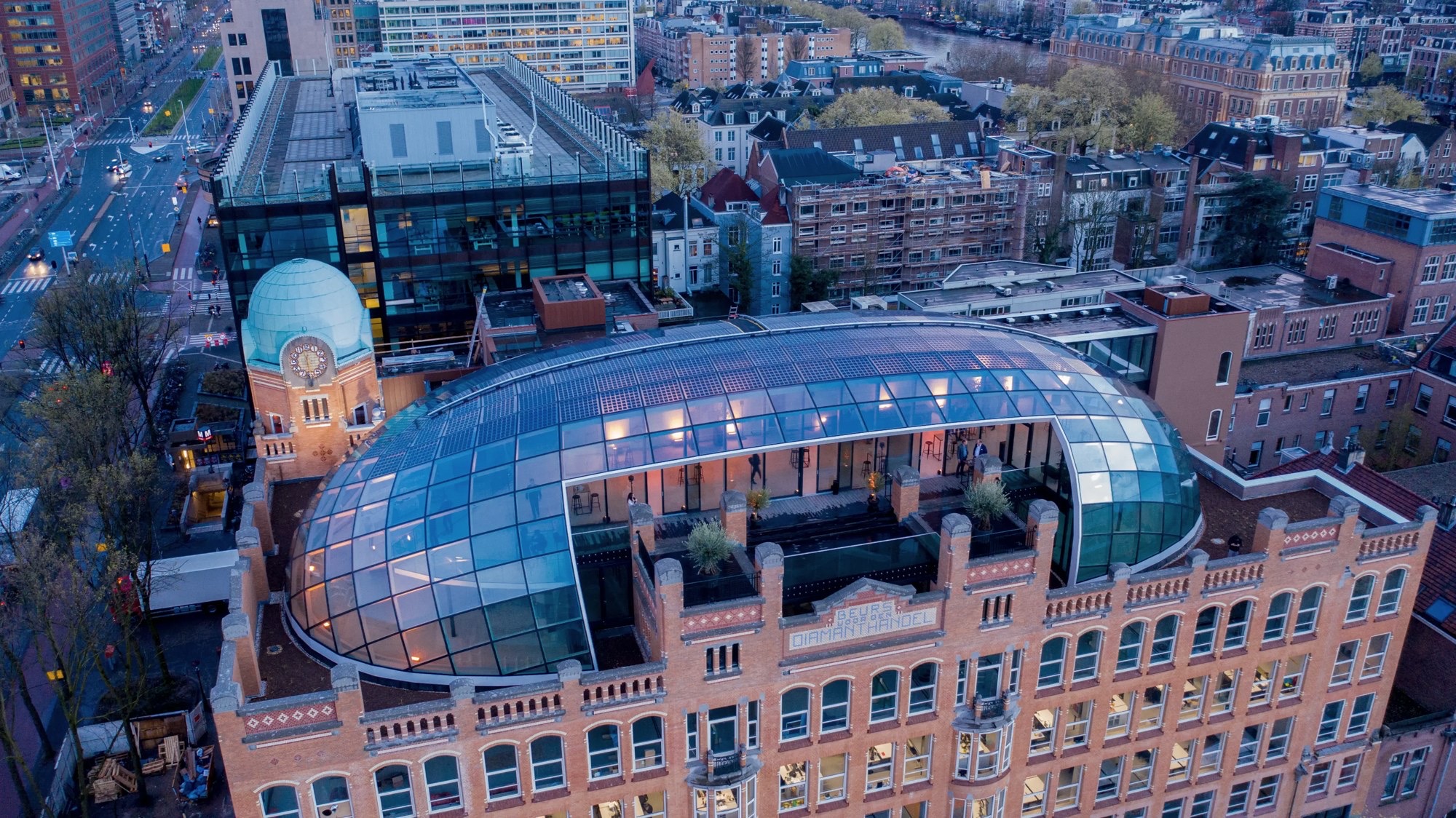 The glass dome of Capital C, the former Amsterdam Diamond Exchange, lit at dusk